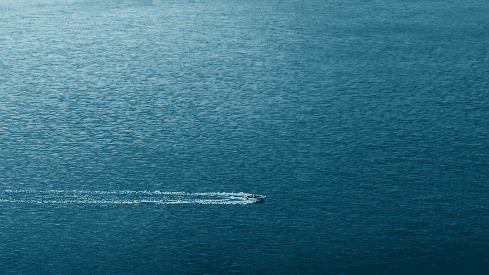 Kleines Speedboat fährt über eine weite blaue Wasserfläche